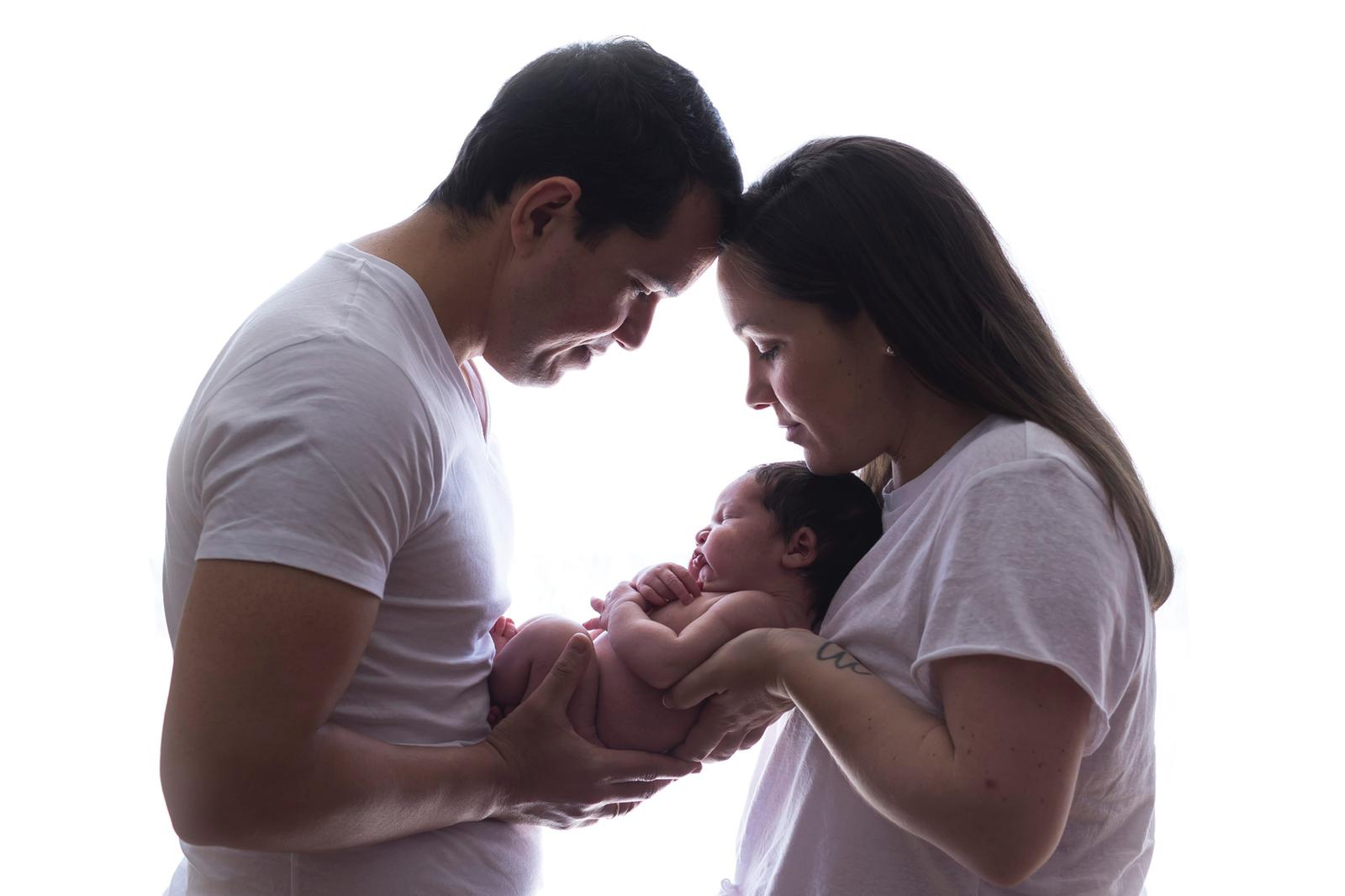 Una madre y un padre sosteniendo a su bebé recién nacido